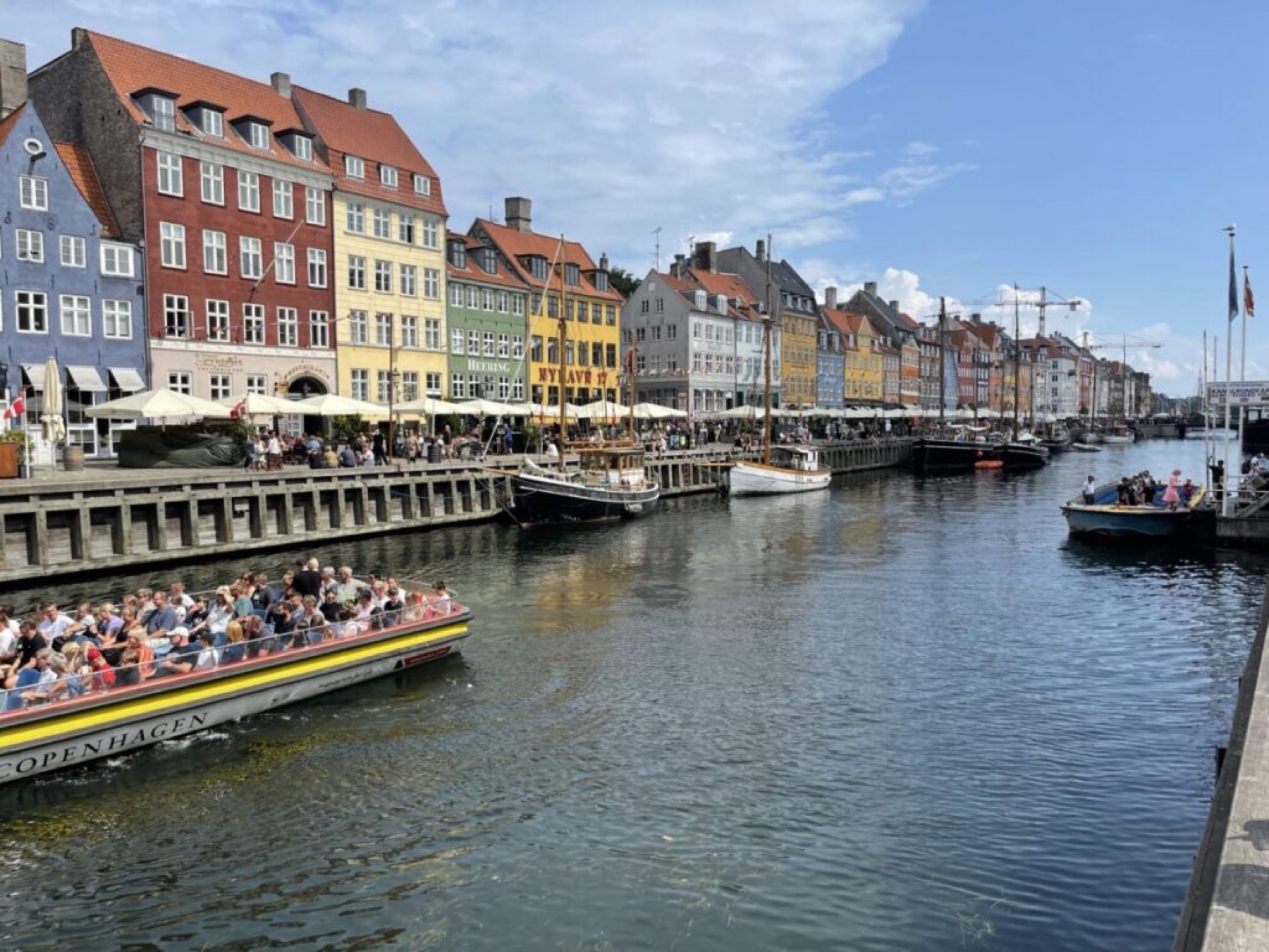 De kleurrijke haven van Nyhavn in Kopenhagen met boten en terrassen